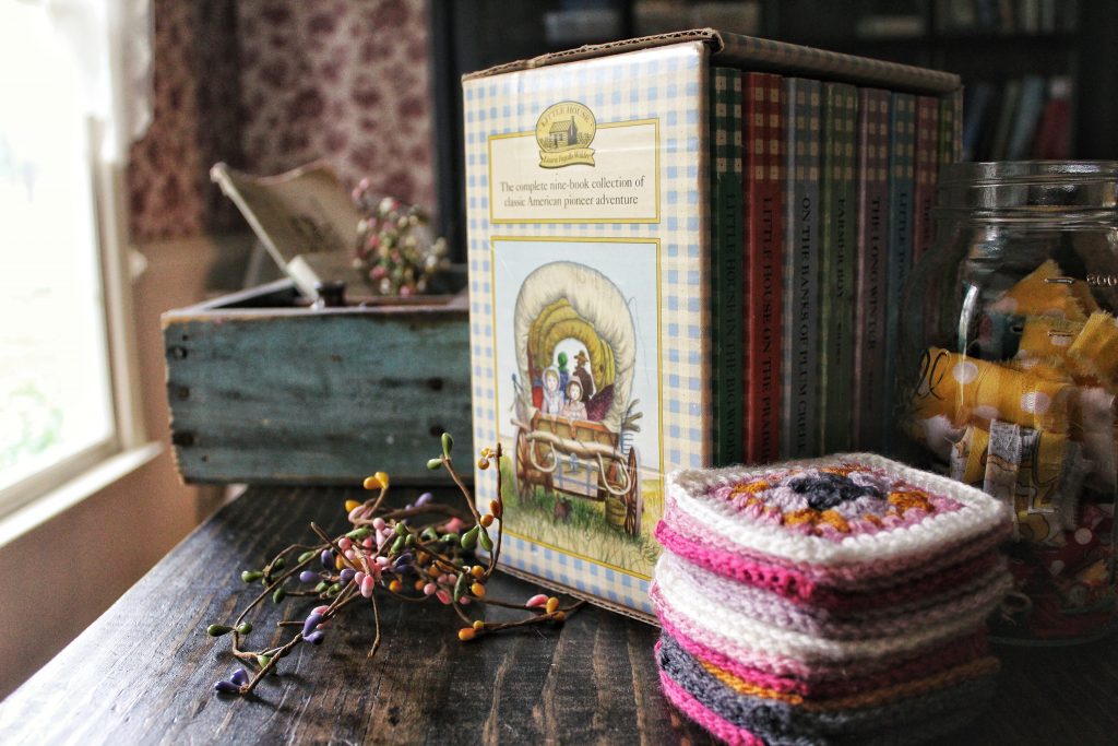 Little House on the Prairie books and stacked granny squares. 